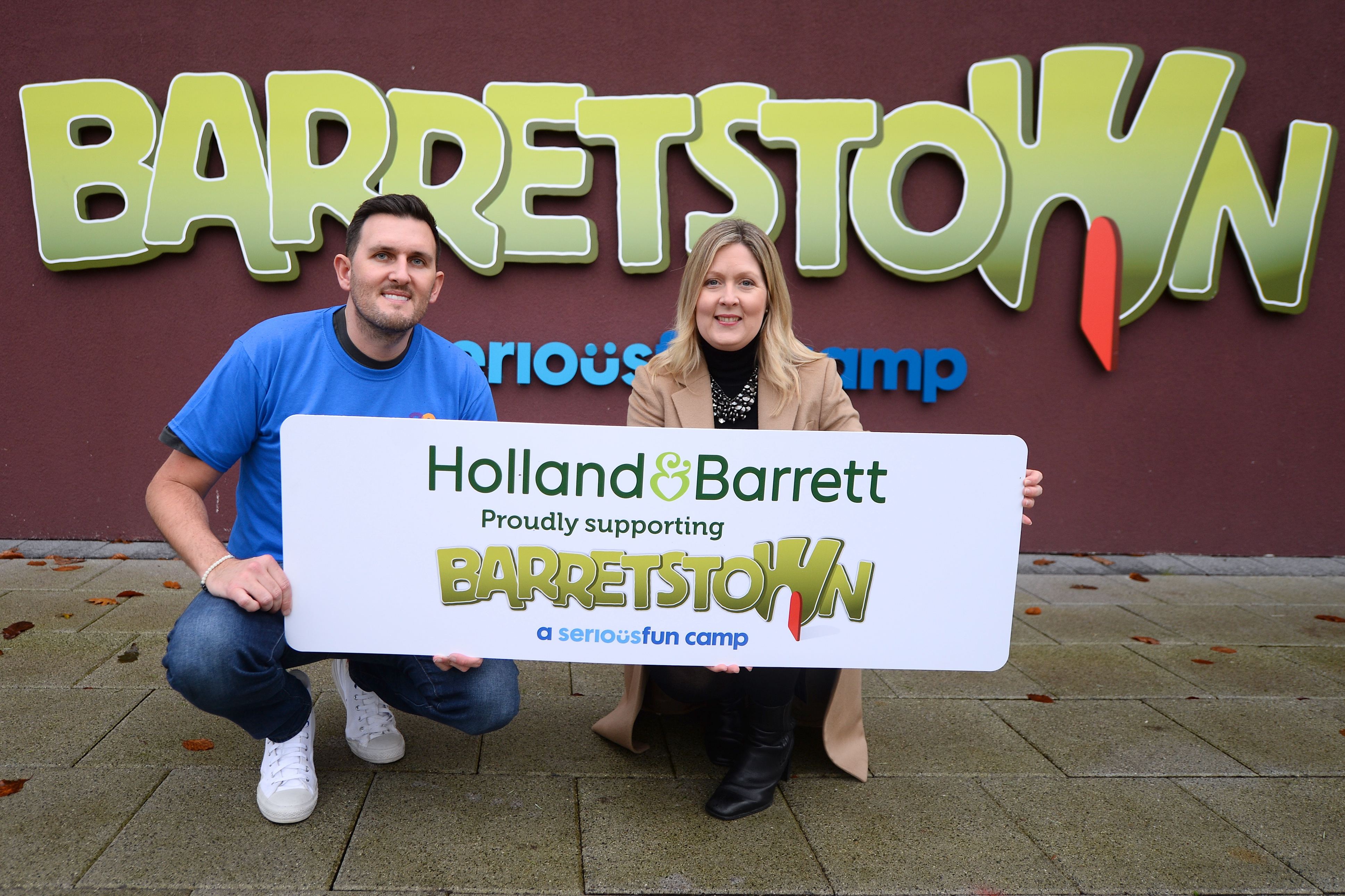 Colleagues holding Barretstown banner