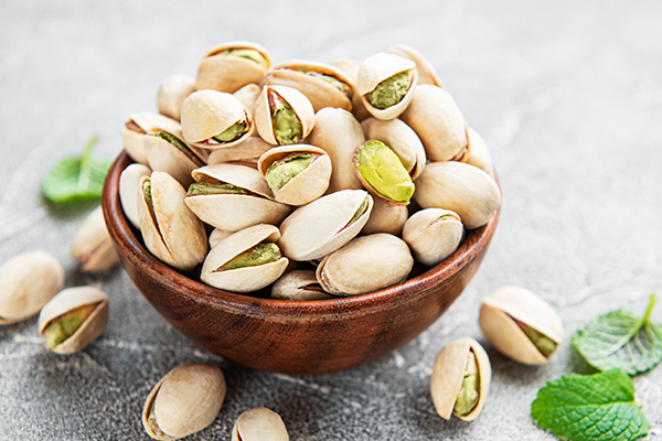 Bowl with pistachios on a grey concrete background