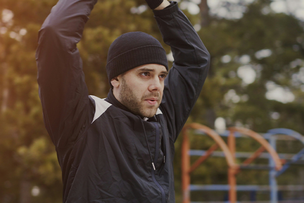 Male stretching in the park before workout
