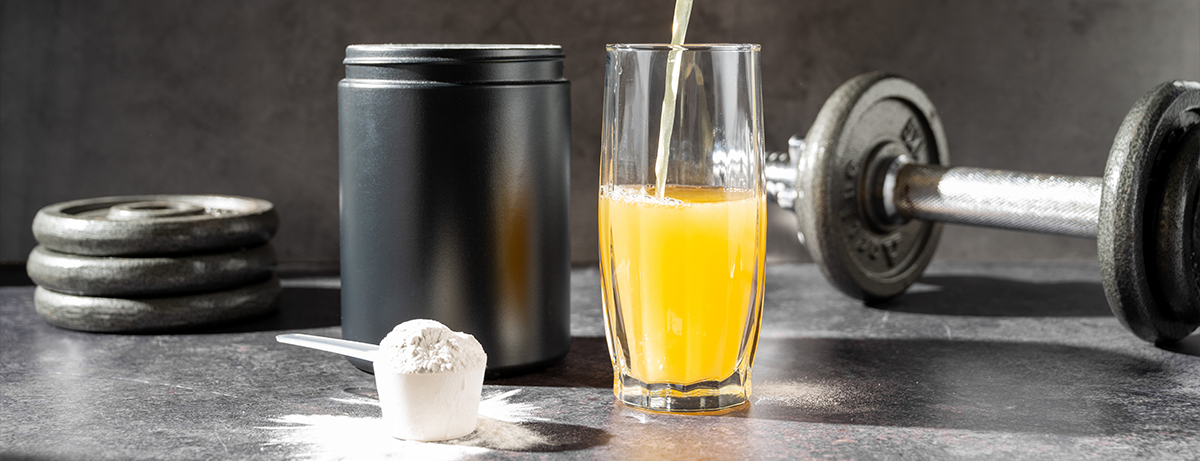 Creatine drink being poured into a glass on counter