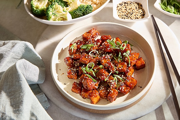 Portion of sticky tofu bites on white plate