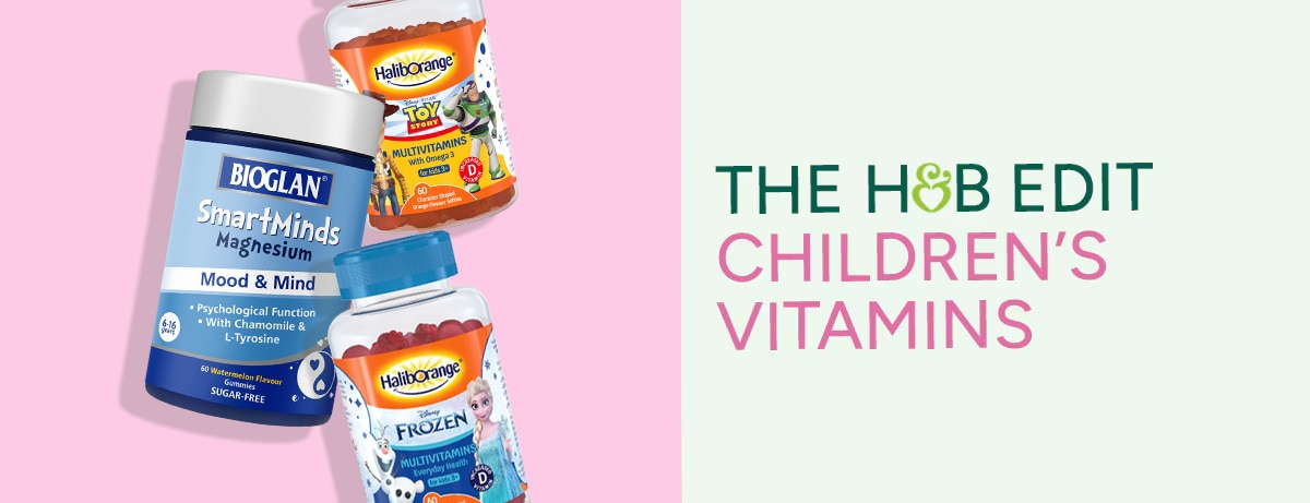 Selection of children's vitamins stacked on pink background