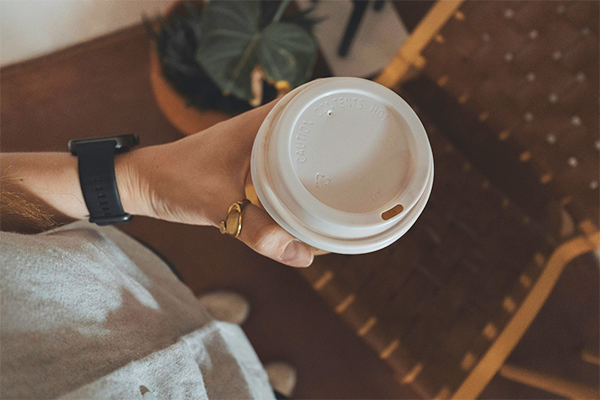 Hand holding a take out coffee cup