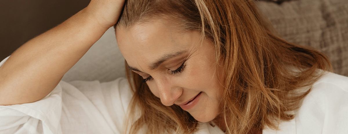 Female with calm expression leaning head on hand