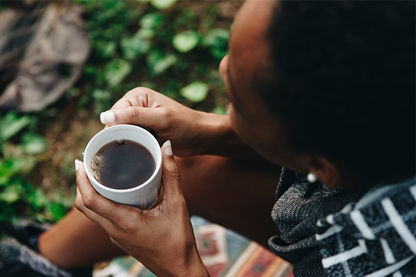 Female holding a cup of black coffee