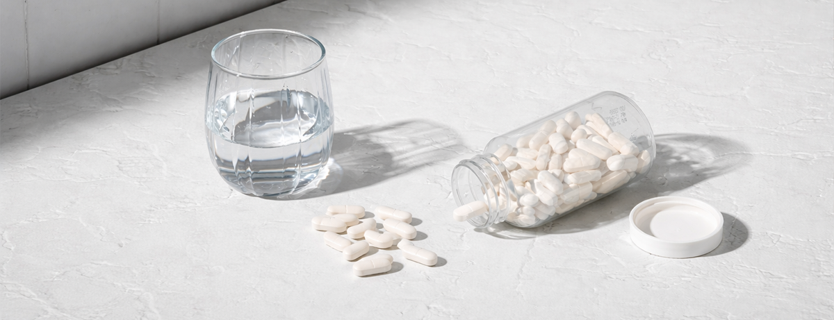 Selection of capsules on a worktop next to a glass of water