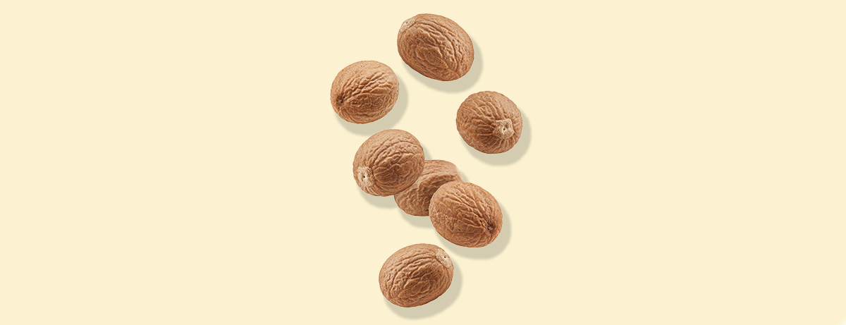 Nutmeg shells falling on yellow background