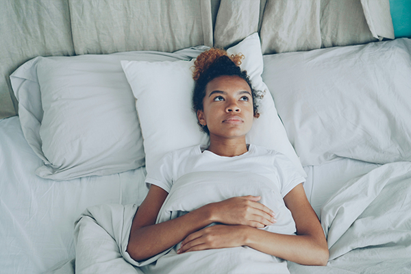 Female laying in bed with eyes open