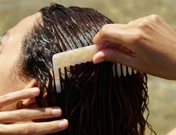 beach woman summer sun happy hair vacation friendship back detail summer fun comb wet hair beach fun happy holiday beach hair combing hair barcelona spain