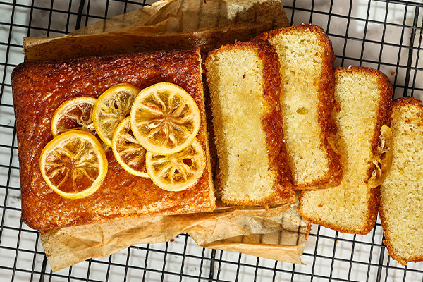 Sliced lemon drizzle cake on cooling tray