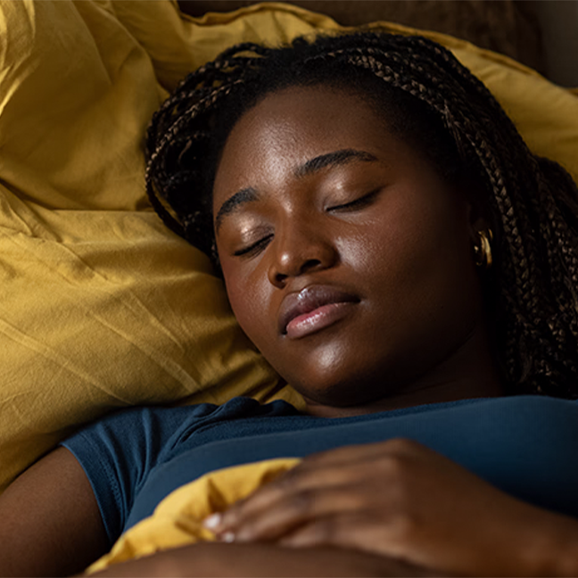 Female laying in bed with a calm expression.