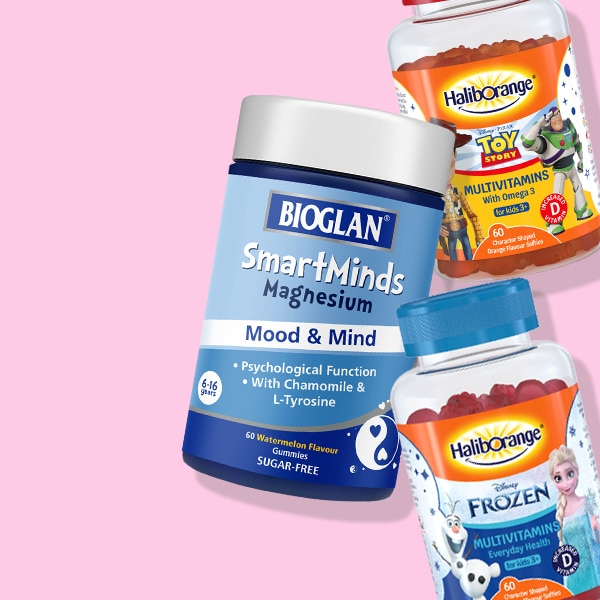 Selection of children's vitamins stacked on pink background