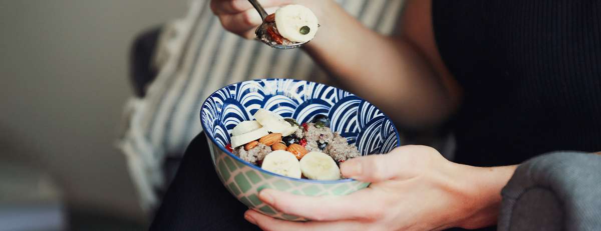 Hands close up holding bowl of granola and fruit