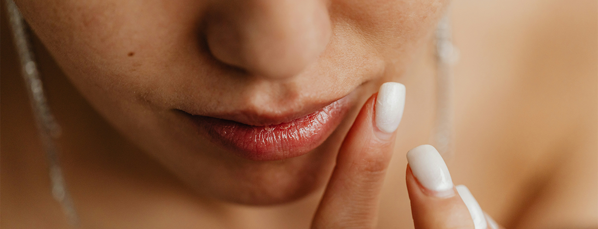 Female adding gloss to lips, close up shot