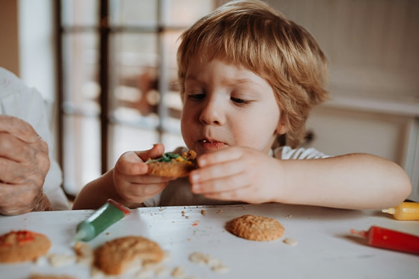 Child eating snacks from kitchen table
