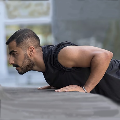 man leaning on bench to do press ups with focussed face
