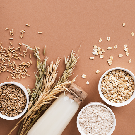Oat products from flakes, milk, flour and whole grains top view. Healthy food, vegetarian diet concept.