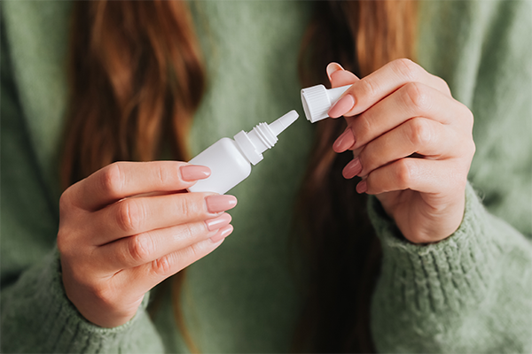 Female holding ear drop bottle