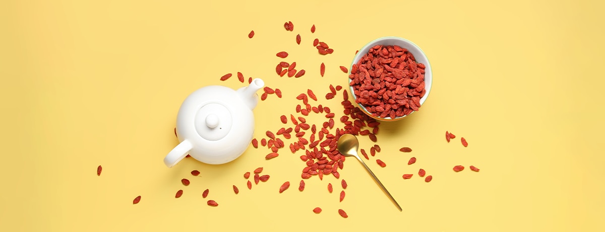 Scattered goji berries on a yellow background
