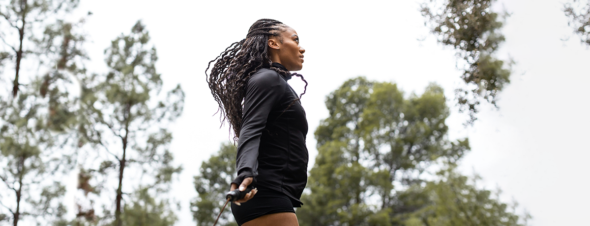 Female skipping in the park surrounded by trees