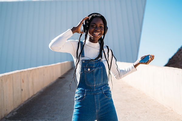 Lady in denim dress dancing with headphones