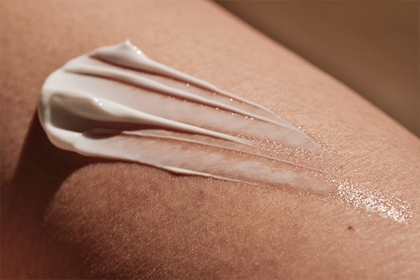 Vitamin C cream on skin, close up