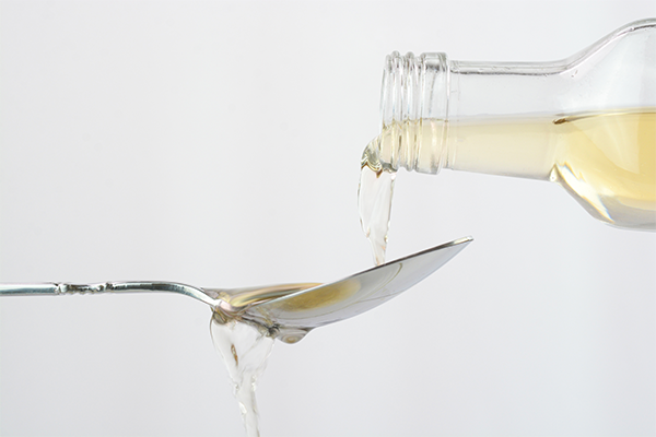 Apple cider vinegar being poured onto a spoon