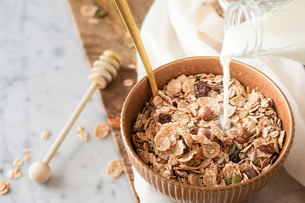food kitchen wellness cooking breakfast marble milk healthy bottle eating nuts cook bowl seeds eat cereal oats spoon countertop muesli
