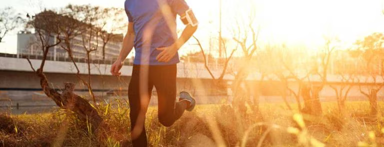 hero image of man jogging through grassy field to support health and hormones for a healthy prostate