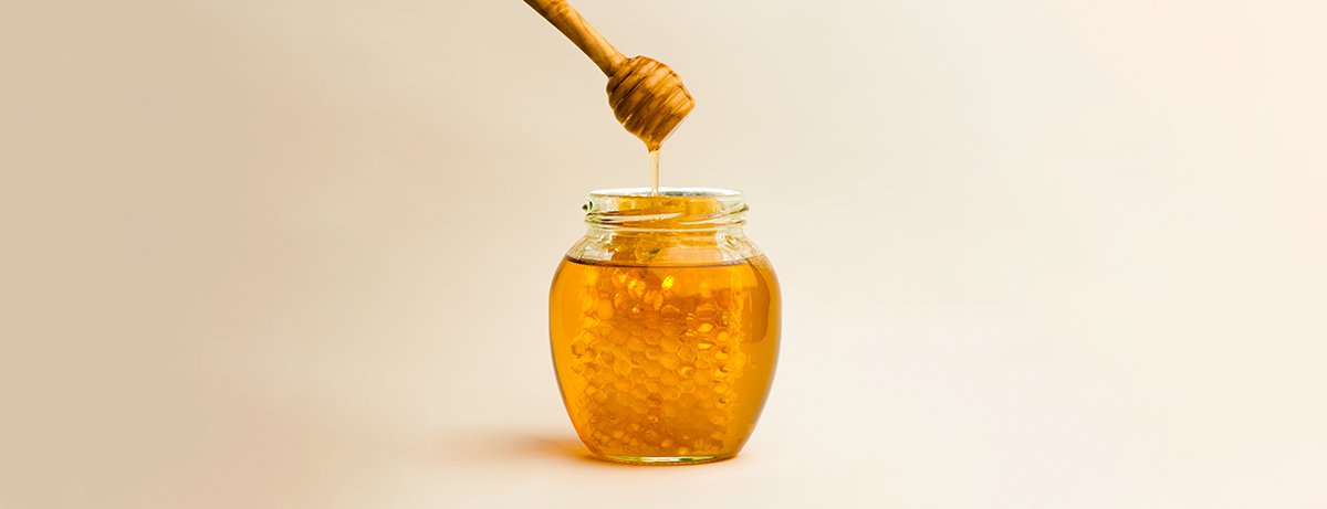 Jar of manuka honey on beige background