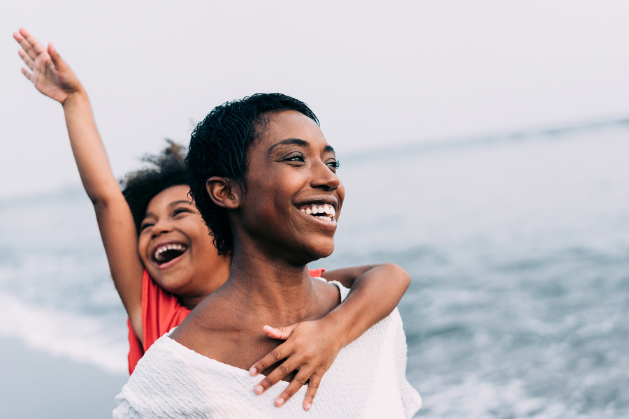 mother and daughter smiling on the beach