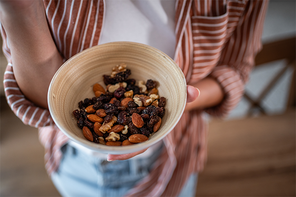 Female holding a bowl of nuts