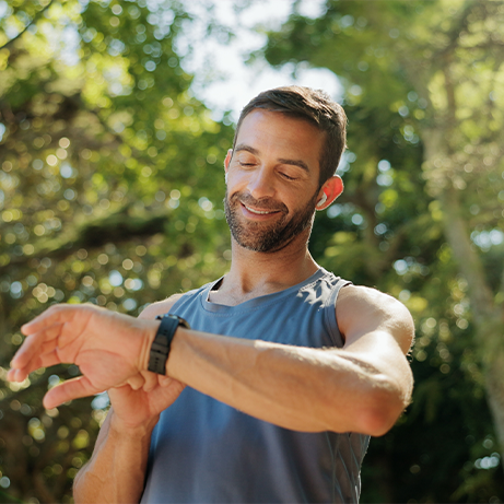 Happy, fitness and man in park with time for exercise, training and workout in morning. Sports, runner and person check smart watch for heart rate and progress for health, wellness and performance