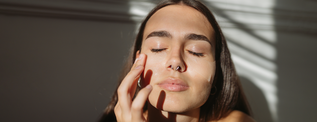 Female applying face serum to skin