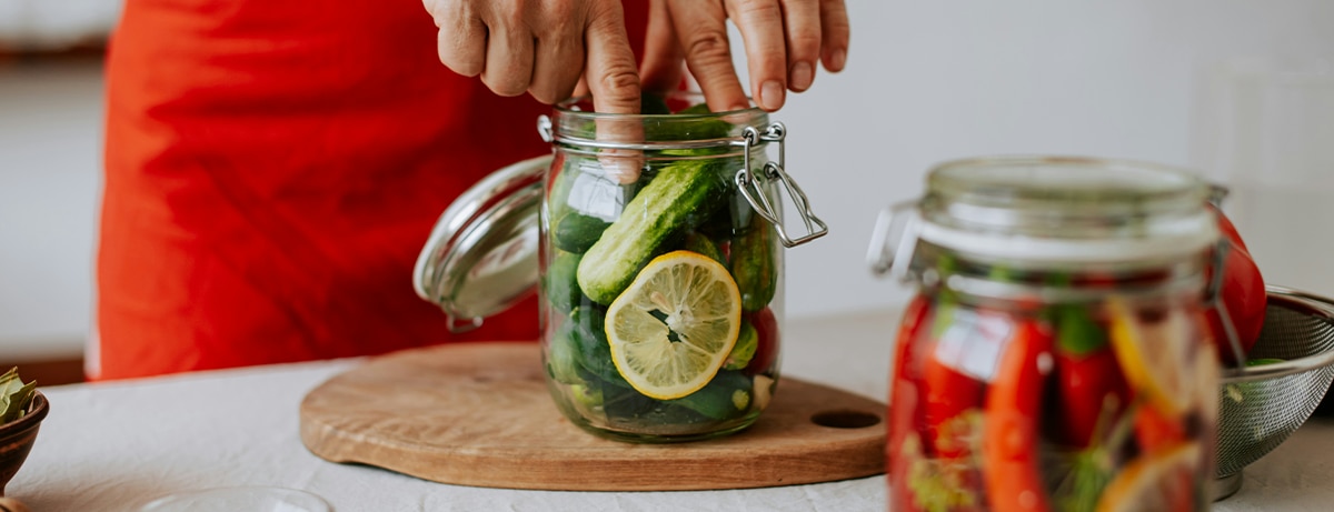 Female standing in the kitchen pickling fruit and vegetables