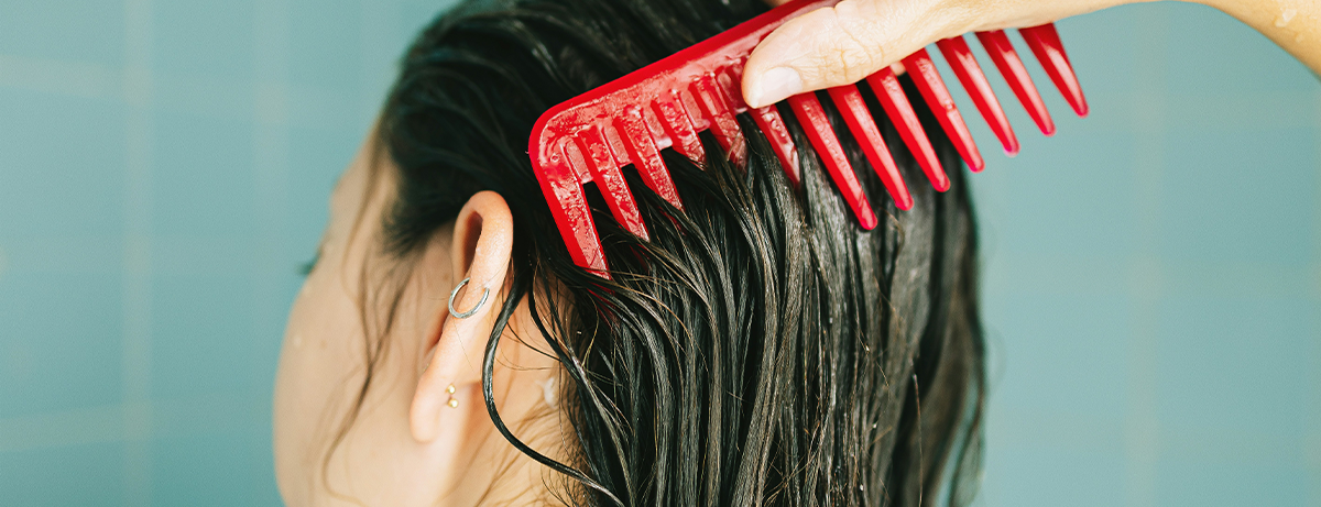 Female combing wet hair in the shower