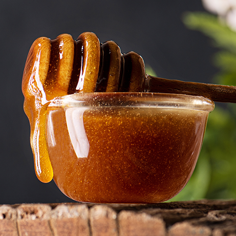 New zealand manuka honey dripping from wooden dipper