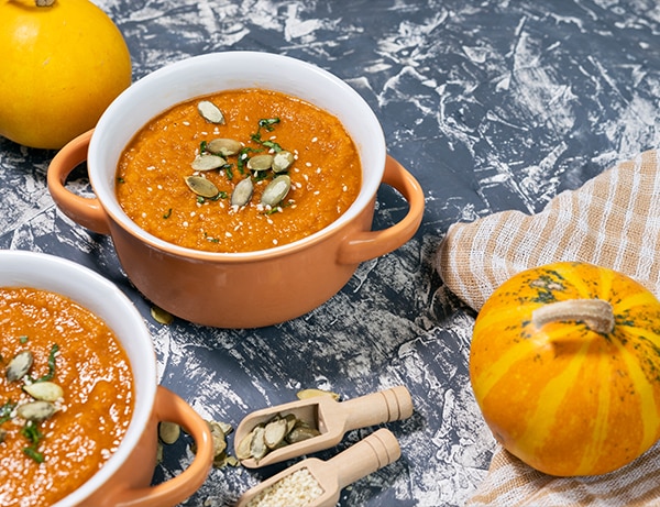 Pumpkin cream soup with seeds, sesame and rucola. Autmn flat lay.