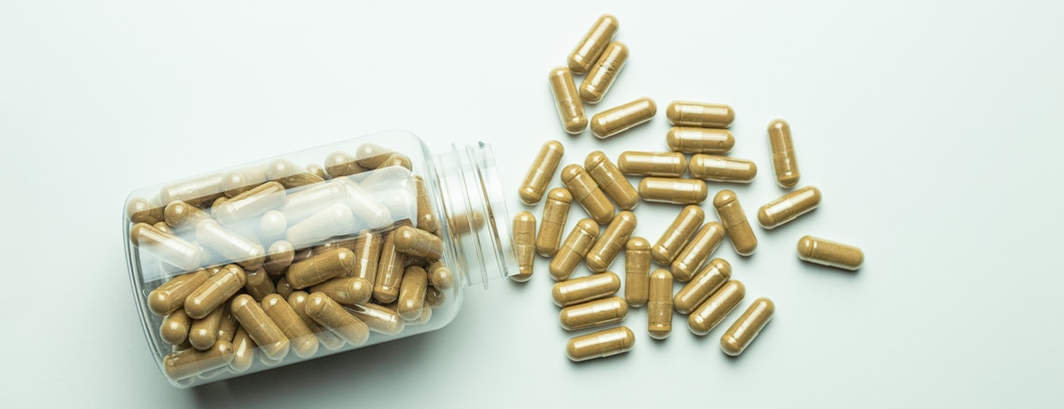 Ashwagandha pills with packaging on a white background