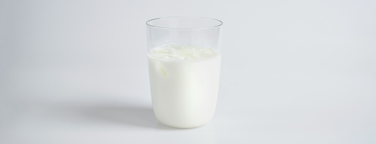 Glass of milk on white background