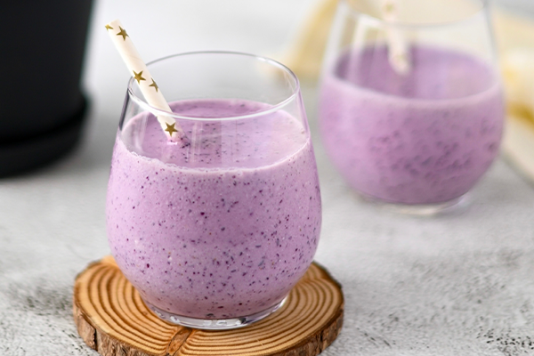 Purple smoothie in glass on table