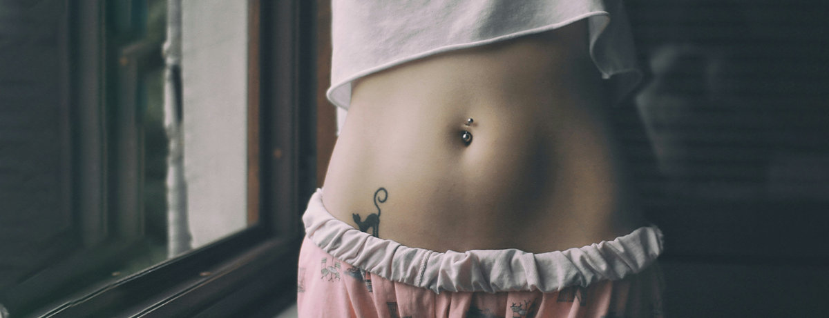 Female standing with arms up showing stomach