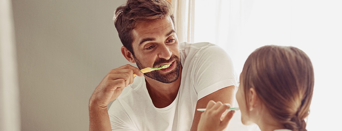 Brushing teeth, father learning and child in a bathroom at home in morning with dental cleaning. Oral hygiene, kids and dad together in house with bonding and parent love for children with toothbrush