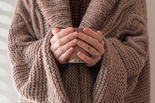 close up of female holding warm mug of tea