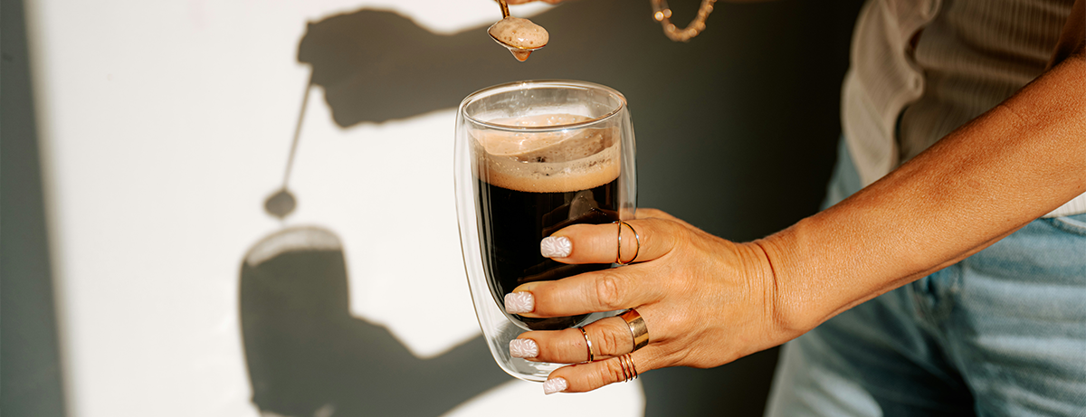 Hand holding a black cup of coffee