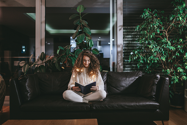 Female sitting on the sofa reading a book