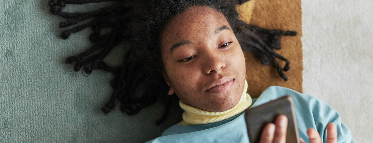 Male laying on the floor looking at phone