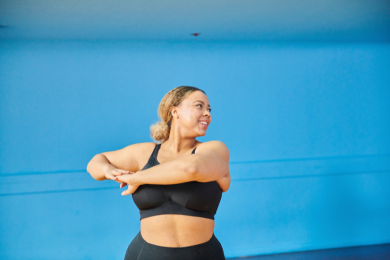 Women preparing for exercise in a sports top against a blue background