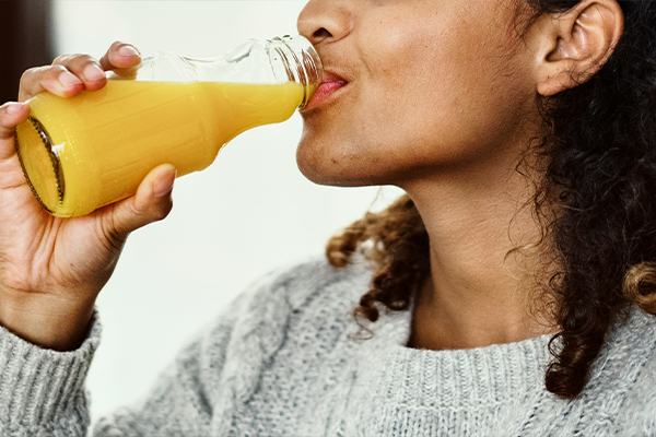 Female drinking orange juice drink