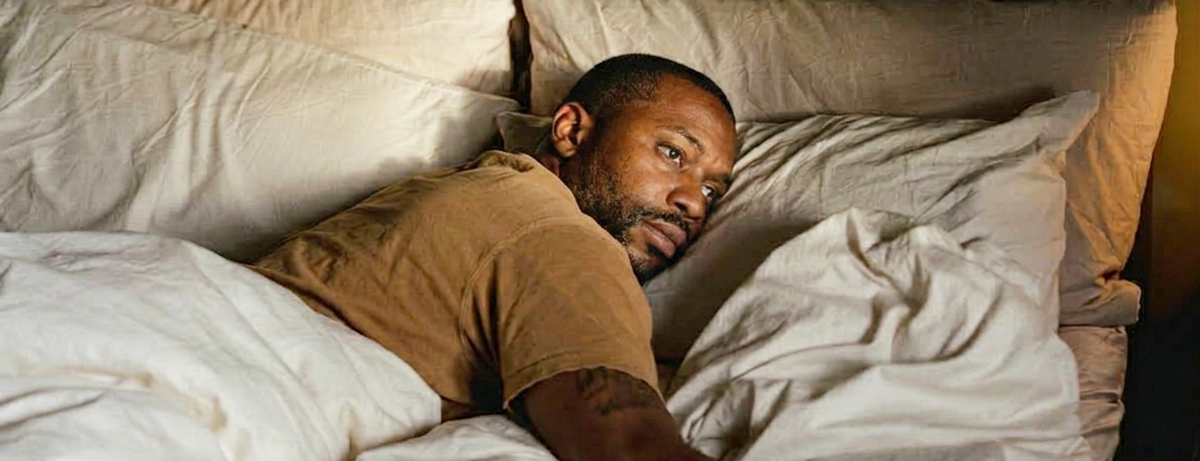 Male in bed looking towards the right, calm expression